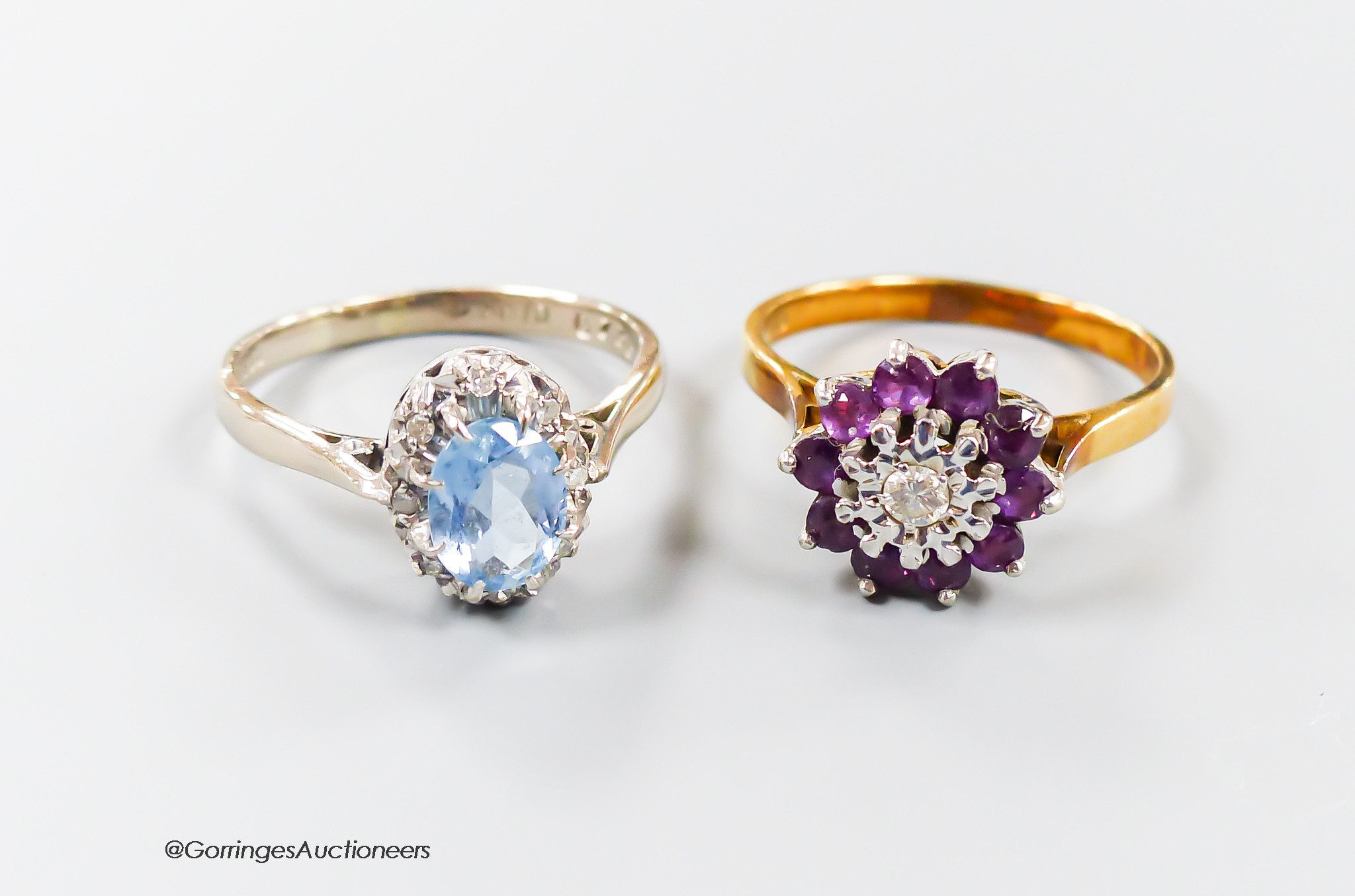 A modern 18th gold, aquamarine and illusion set diamond oval cluster ring, size R and one other 18ct gold, garnet? and diamond set cluster ring, gross 8.8 grams.